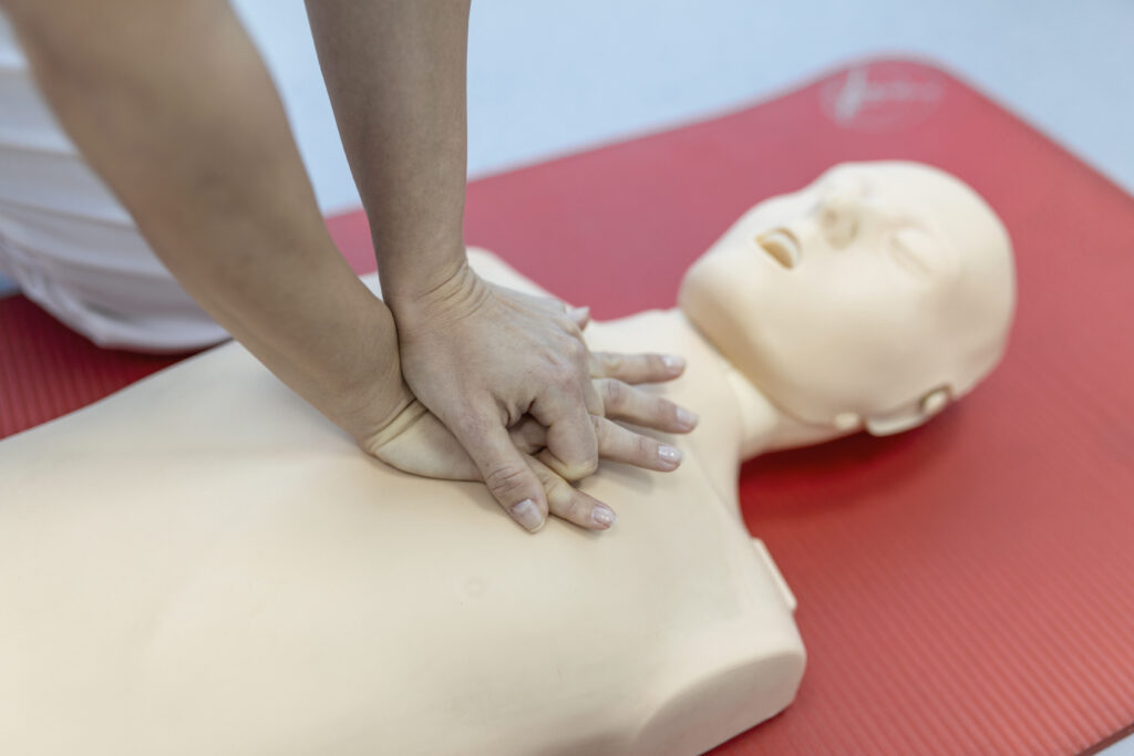 Cours de rcr avec des instructeurs parlant et démontrant les premières compressions d'aide